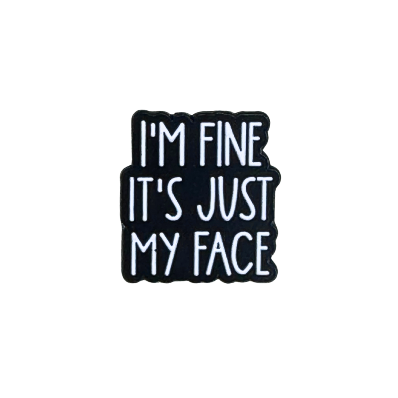 Hero image of a black and white enamel pin that says “I’m Fine It’s Just My Face”