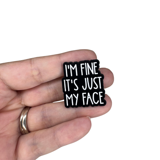 The pin shown being held in hand for scale