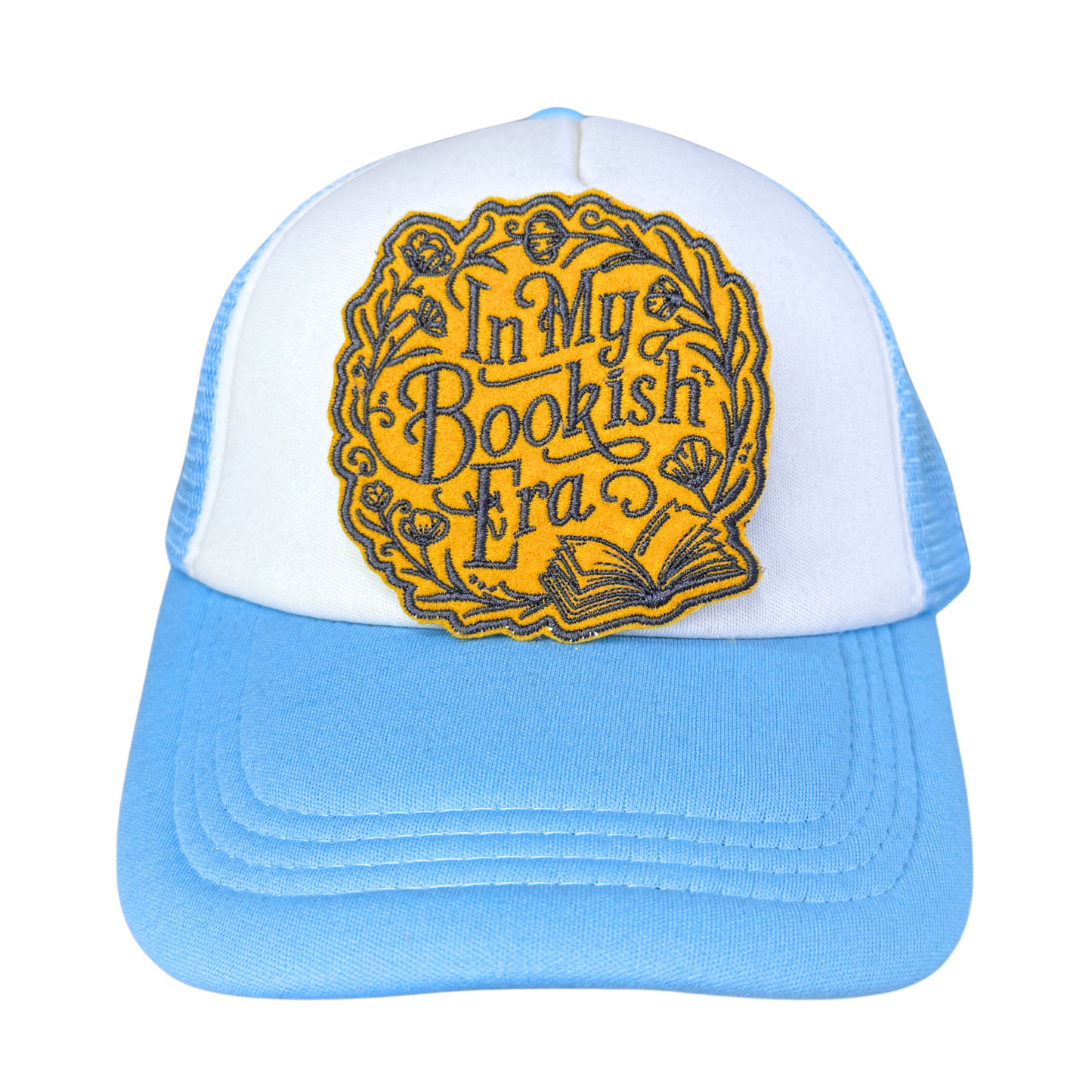 "In My Bookish Era" embroidered patch attached to a light blue and white trucker hat.