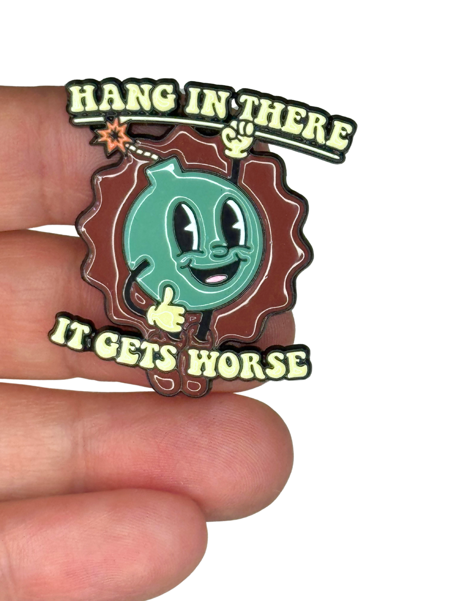 “Bomb pin shown on fingers for scale”