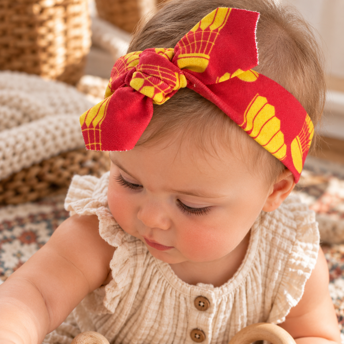 Baby wearing KC shuttlecock red and gold organic cotton tie headband