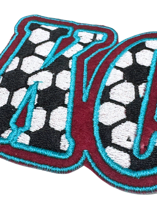 Close-up of KC patch showing soccer ball print texture and embroidery