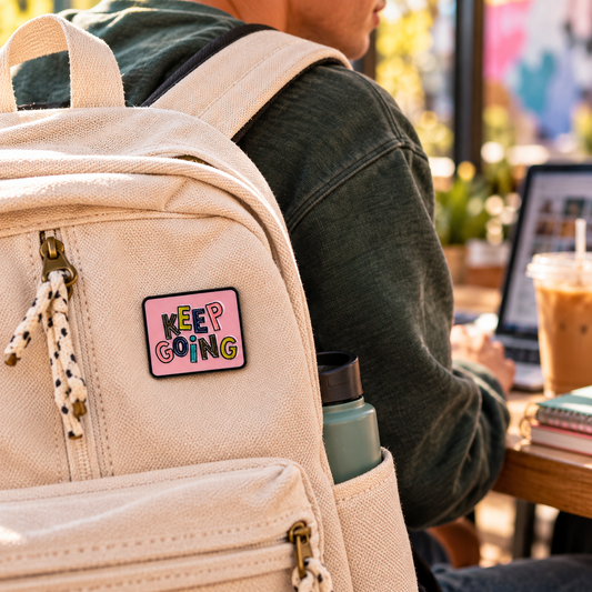 Keep Going pink enamel pin on canvas backpack lifestyle image