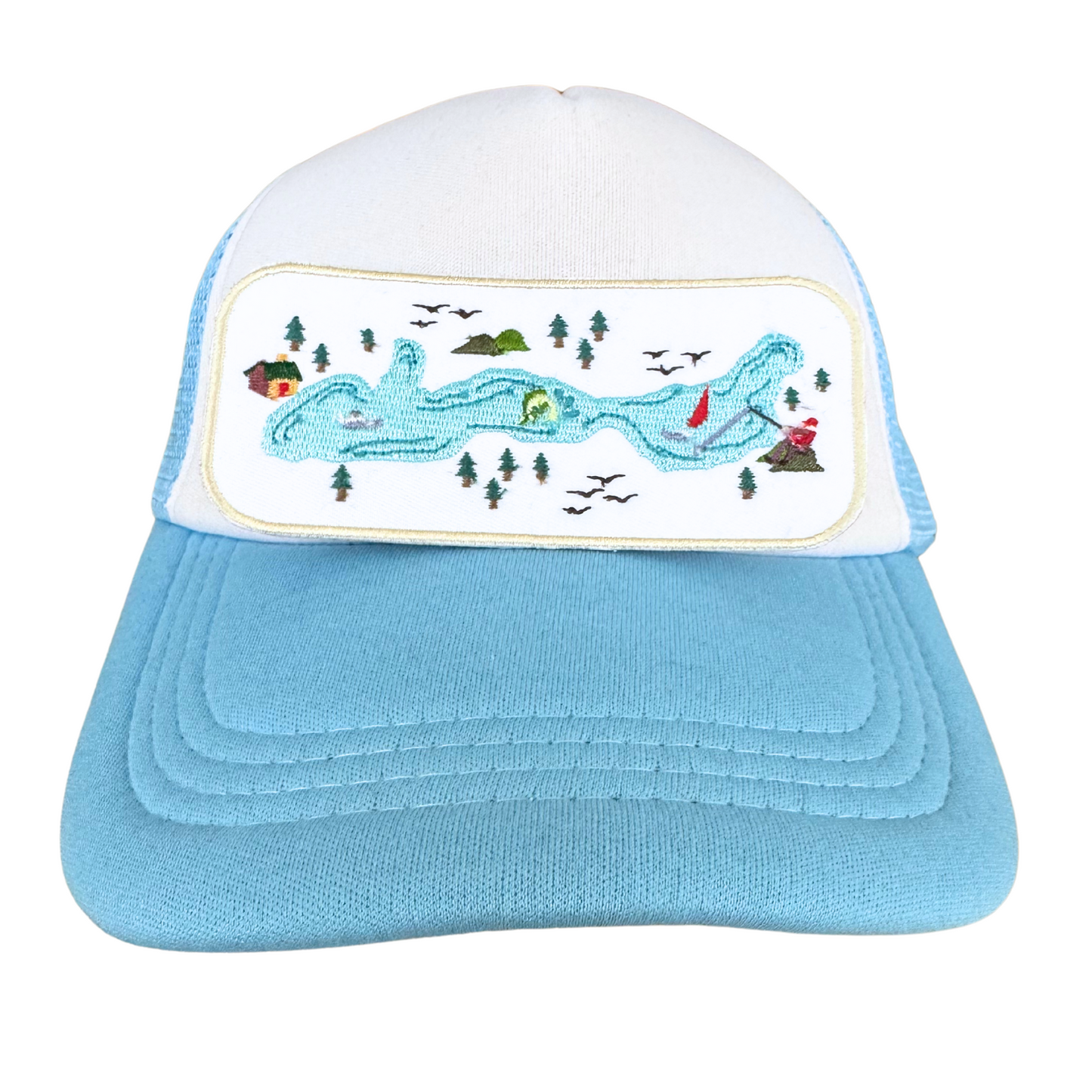 Trucker hat featuring embroidered lake scene patch with winding water, trees, and lake house details