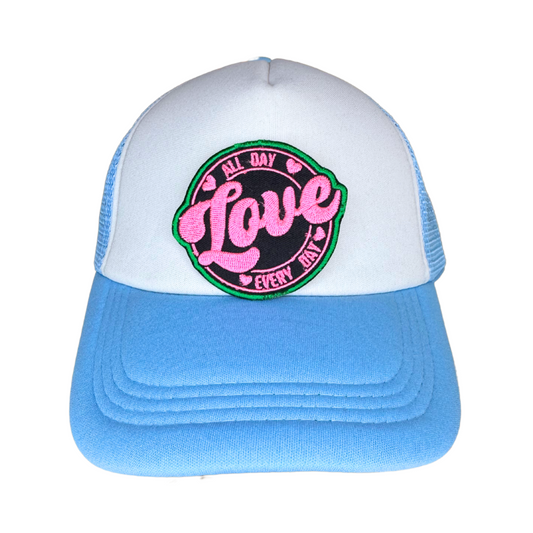 "Love All Day" patch ironed onto a white and blue trucker hat
