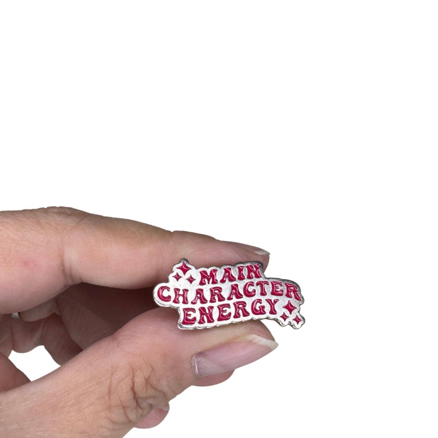 Close-up scale image of the "Main Character Energy" enamel pin held in hand