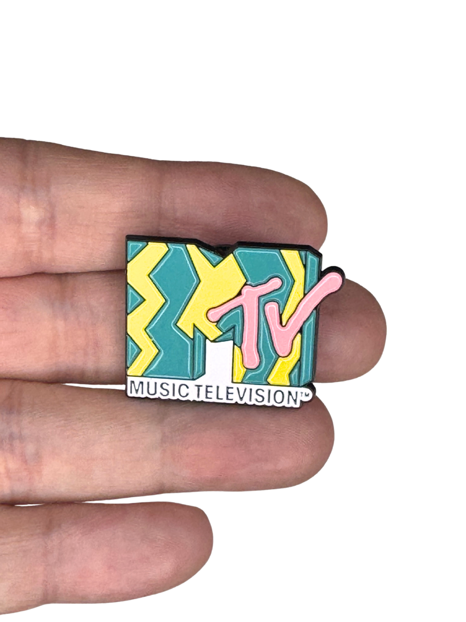 MTV enamel pin shown in hand for size scale