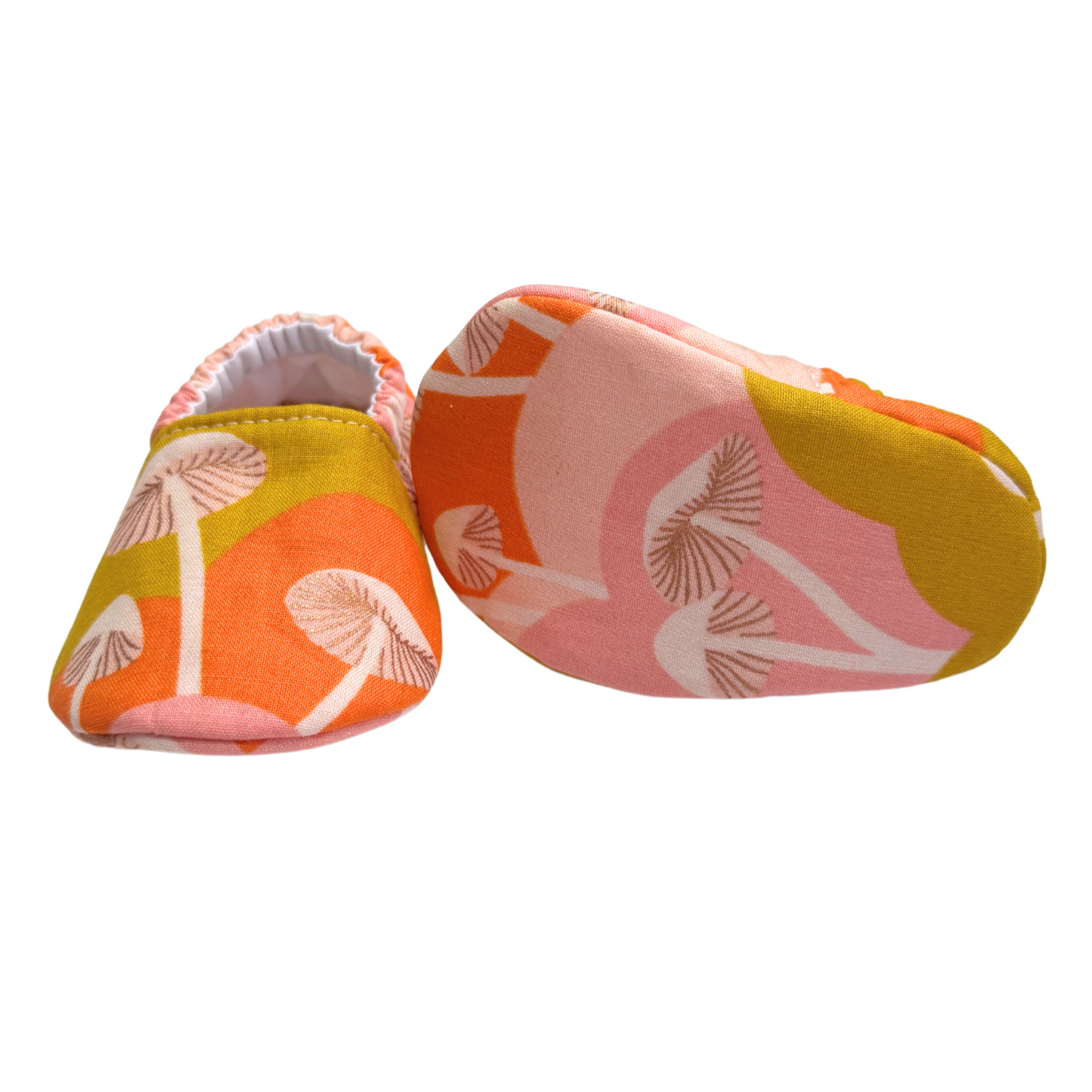 Bottom view of mushroom-print baby moccasins, highlighting the soft and flexible soles perfect for newborns and pre-walkers.