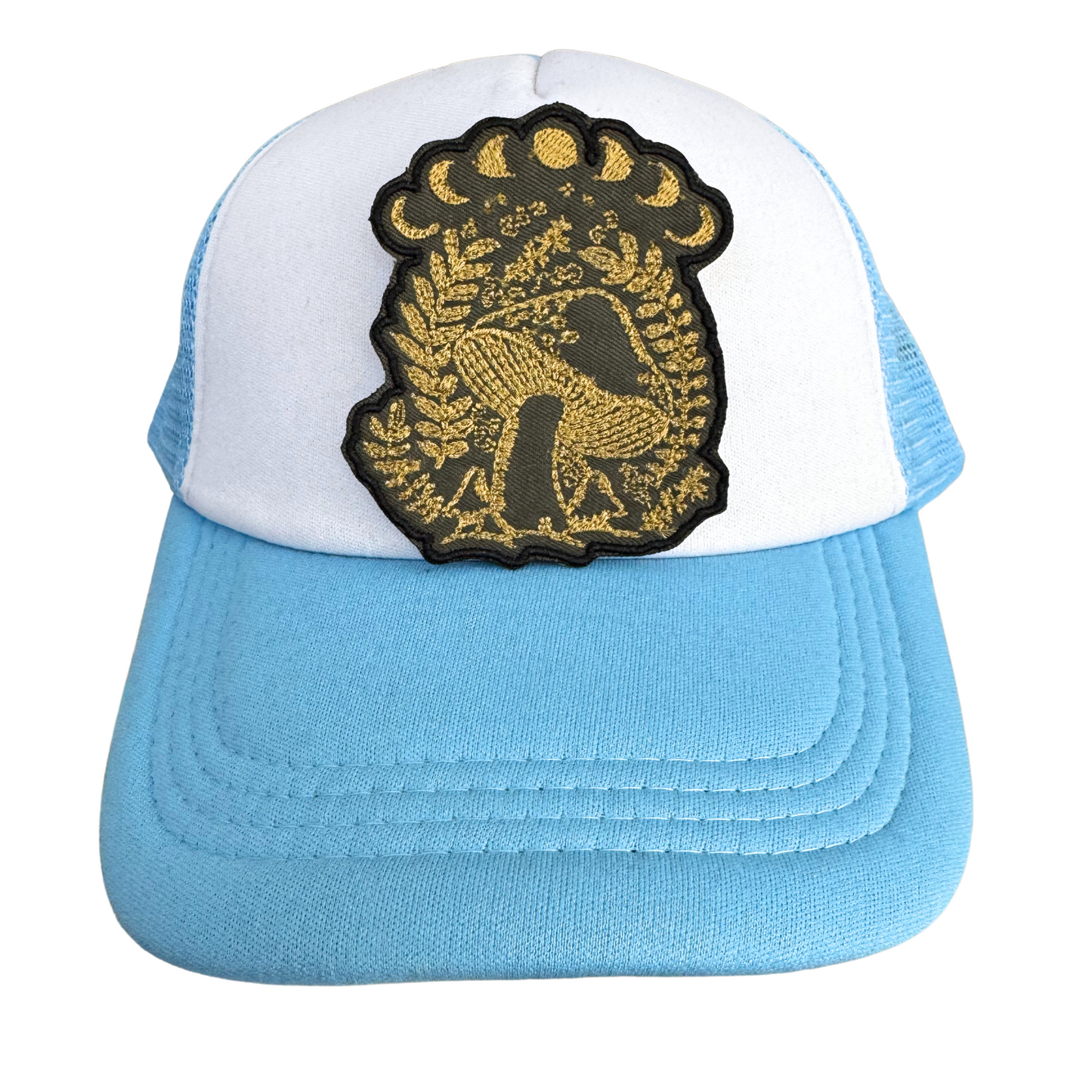 Blue and white trucker hat styled with the Golden Mystical Mushroom Moon Phase patch, perfect for celestial and nature-inspired looks.