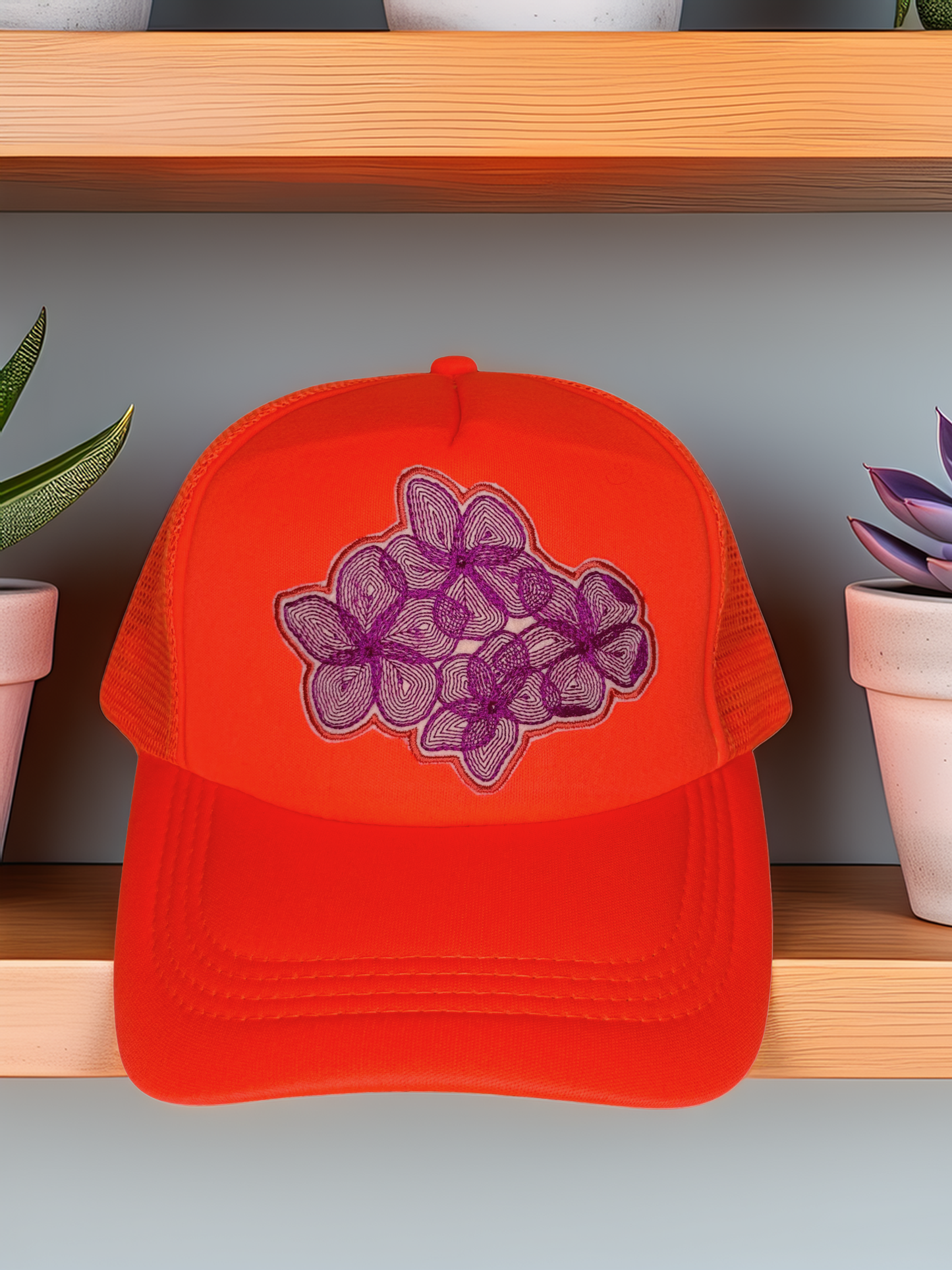 Orange cap with purple floral design on a wooden shelf with plants