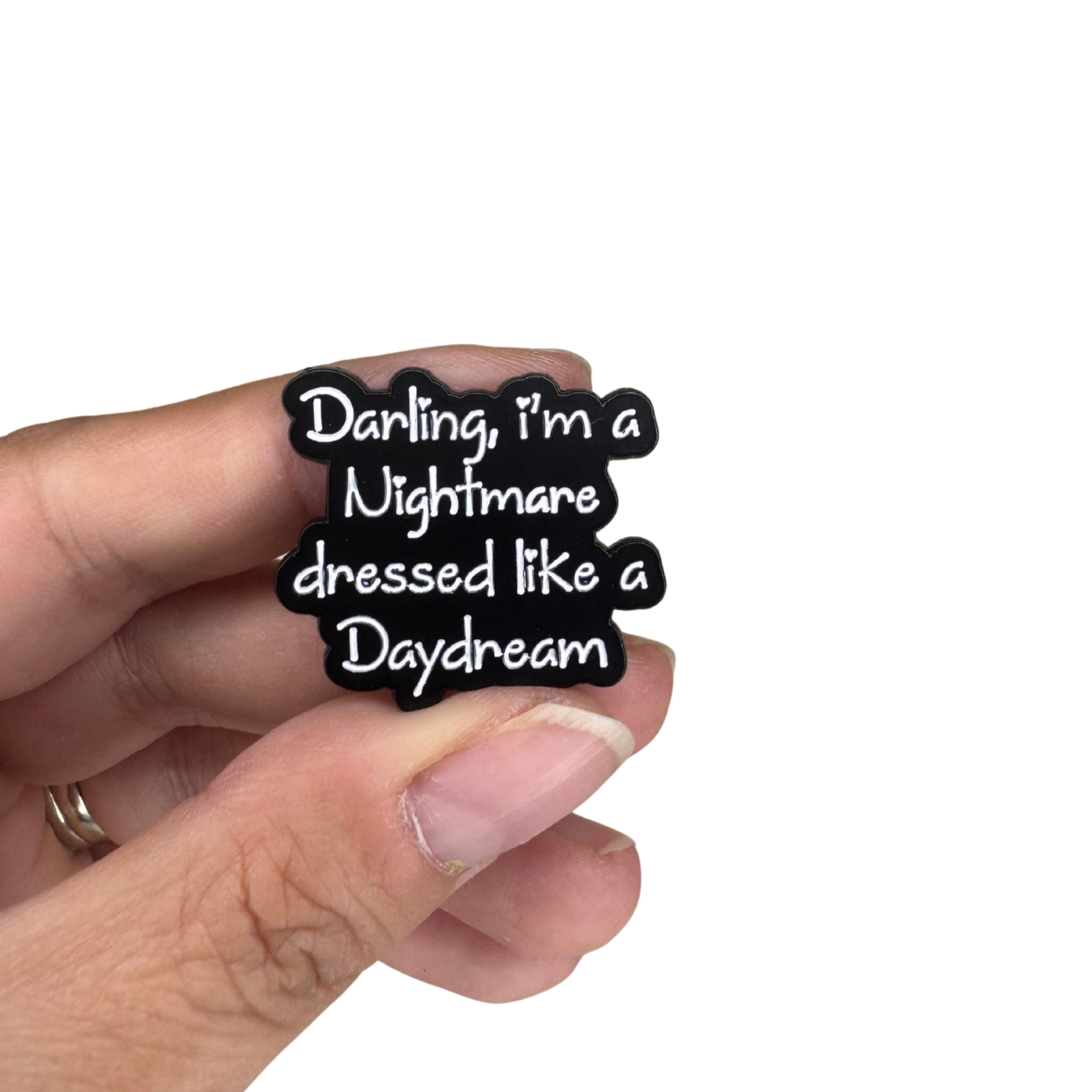 Hand holding the enamel pin for size scale