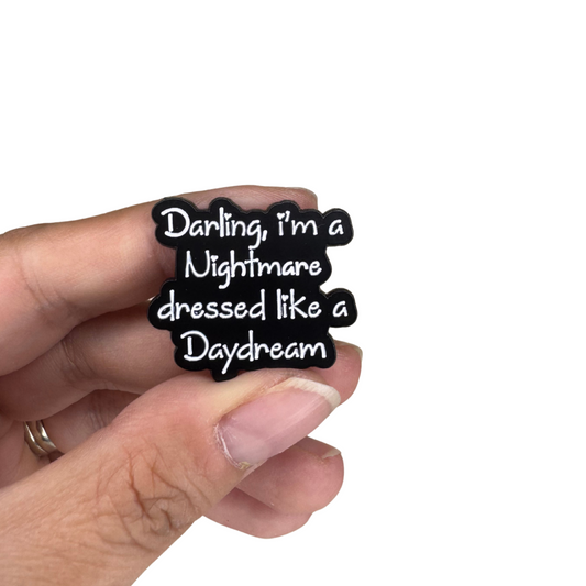 Hand holding the enamel pin for size scale