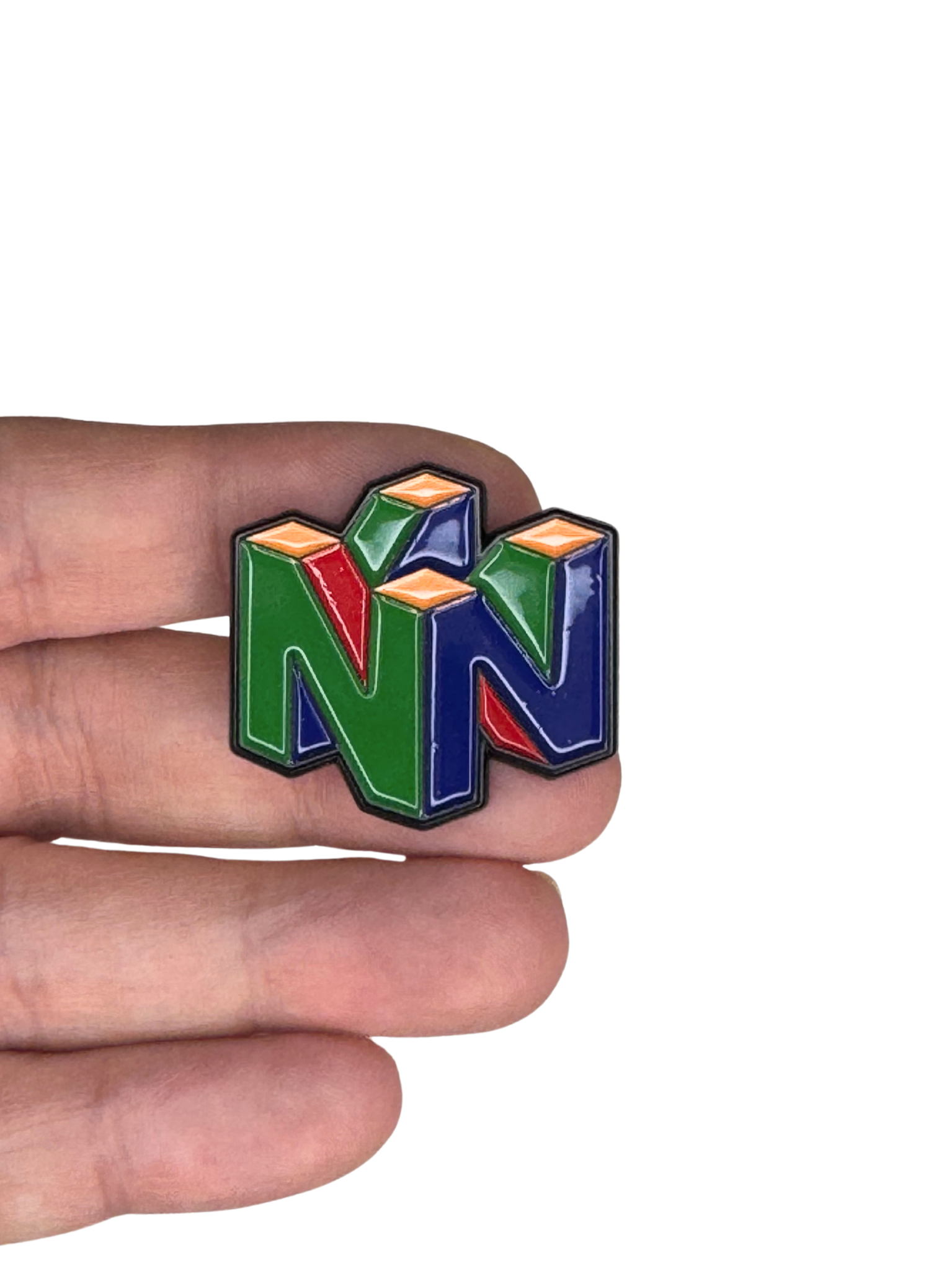 Nintendo 64 enamel pin shown in hand for scale