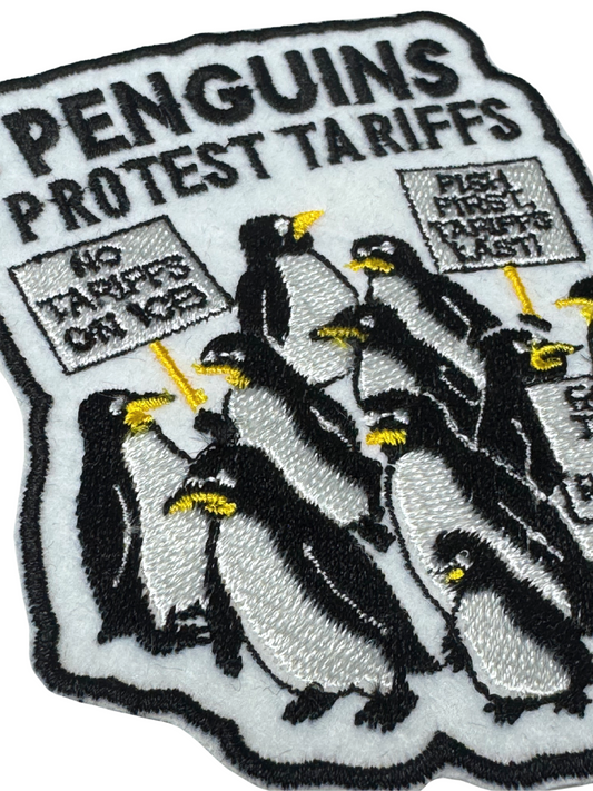 Close-up detail of penguin embroidery and protest signs