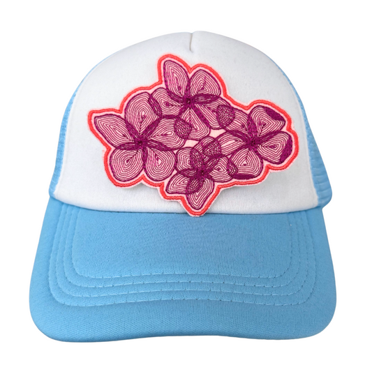 Pink and purple floral patch on blue and white trucker hat