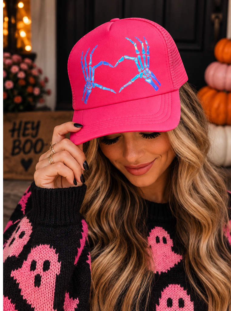 Woman wearing neon pink skeleton heart hands trucker hat for spooky season