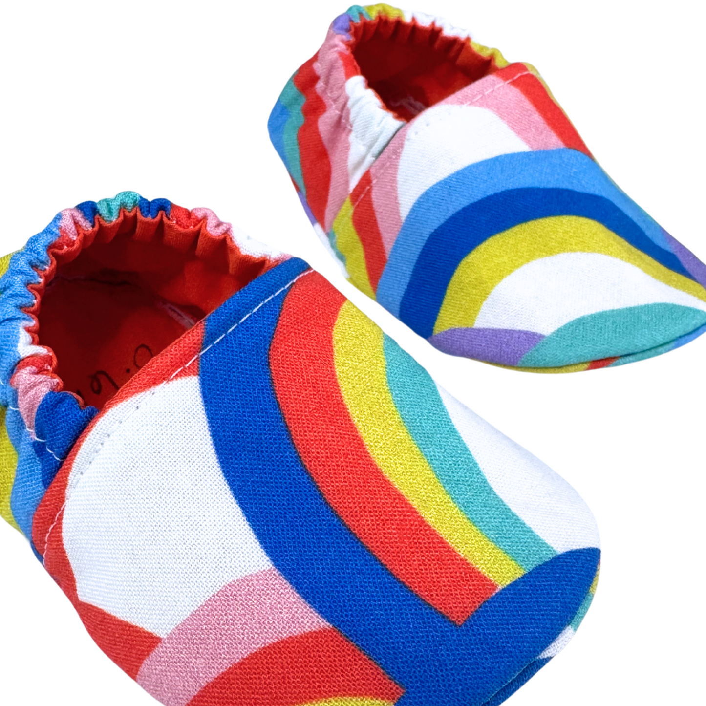 Angled shot of colorful rainbow soft sole baby shoes
