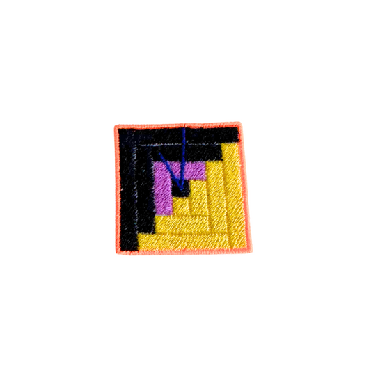 Handmade Safehouse embroidered patch with black, gold, and purple geometric design, representing support for survivors.