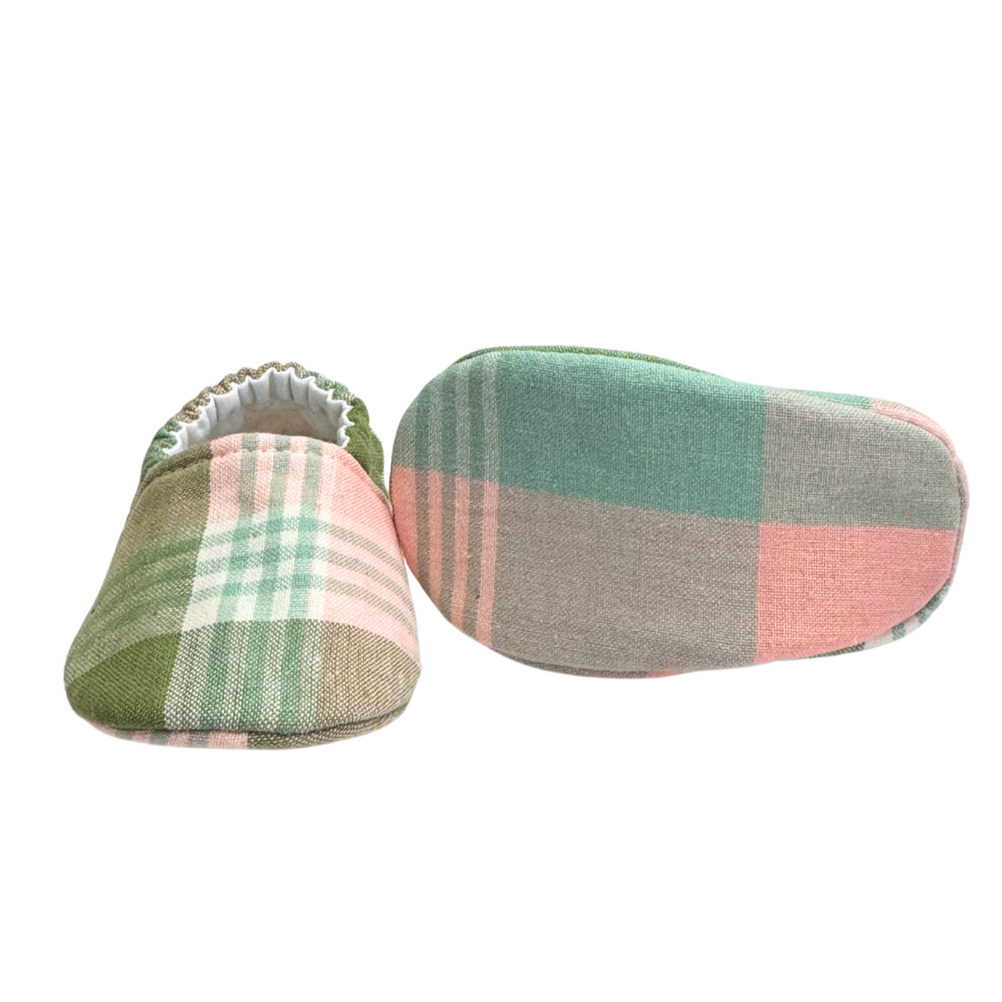 Bottom view of sage plaid baby moccasins, highlighting the soft, lightweight sole designed for newborn foot development and all-day comfort.