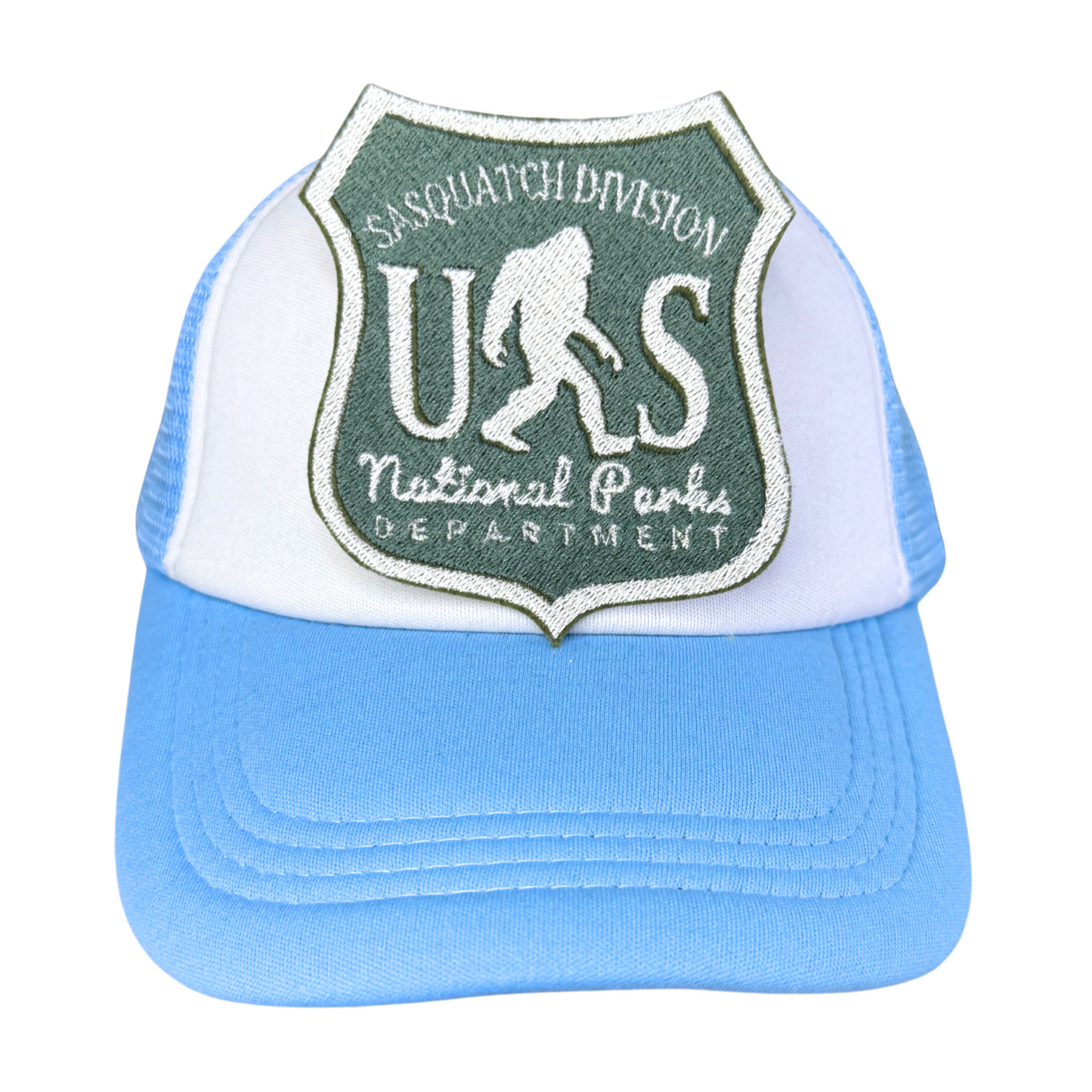 "Blue and white trucker hat featuring an embroidered Sasquatch Division National Parks patch in forest green and white."