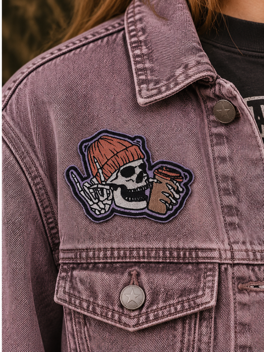 Skull and Coffee embroidered patch worn on a washed mauve denim jacket