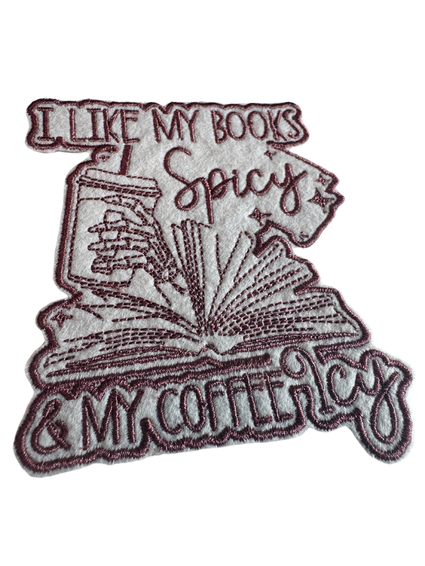 Close-up of spicy book lover patch with burgundy embroidery and iced coffee detail