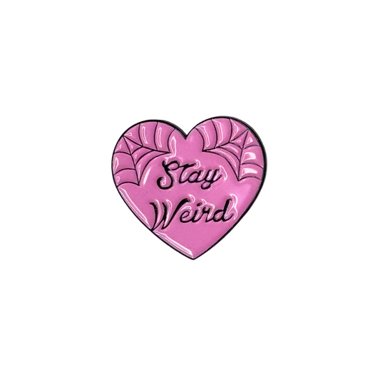 “Pink heart enamel pin with spiderwebs and text ‘Stay Weird’”