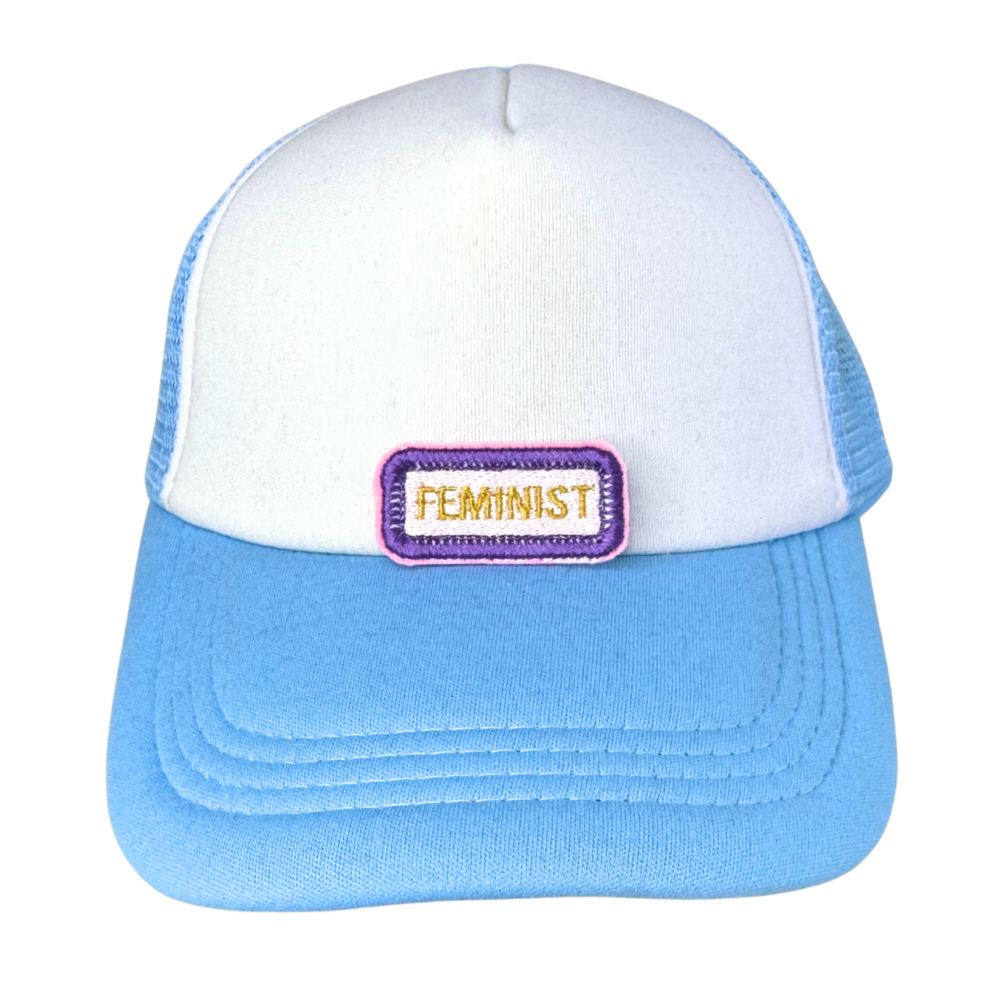 "Blue and white trucker hat with an embroidered suffragette-inspired feminist patch in purple, white, and gold."