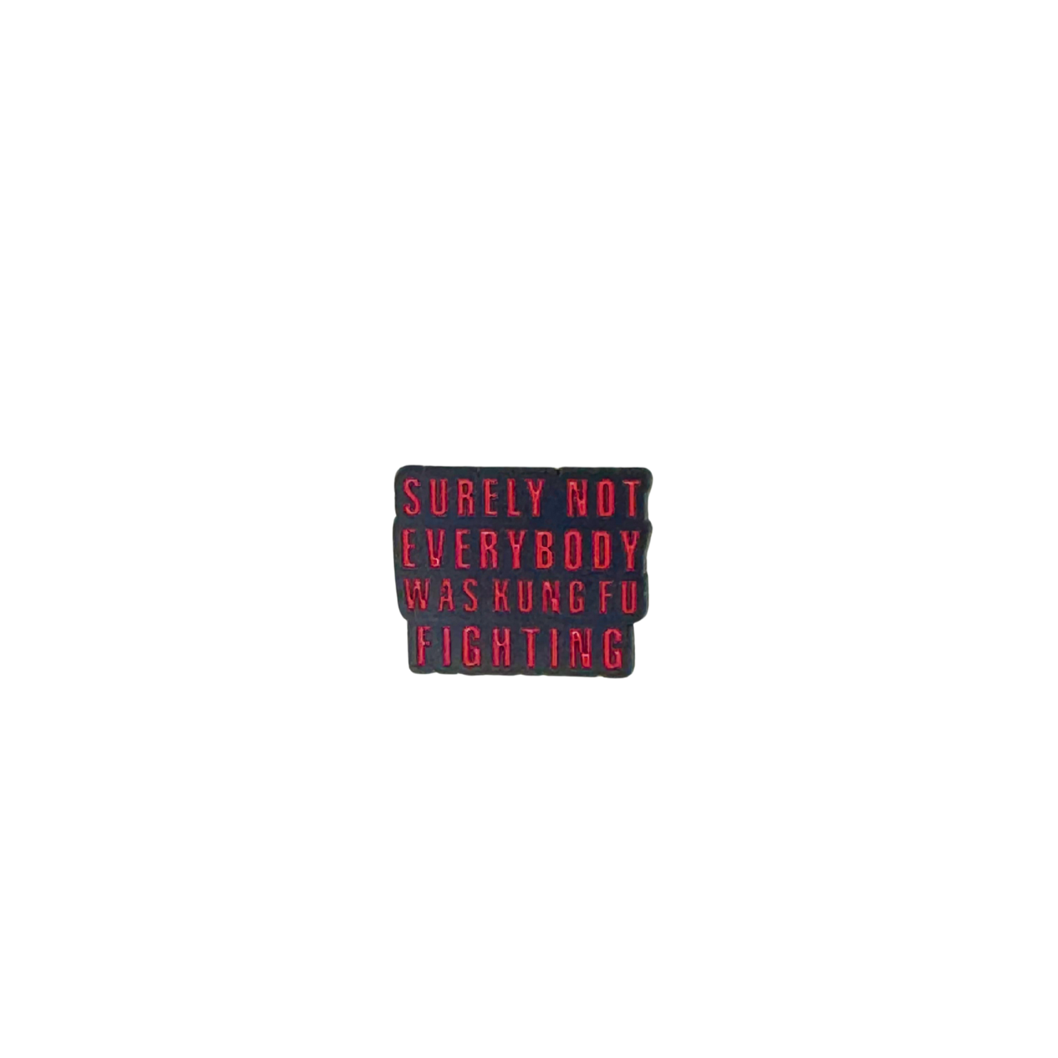 Red and black enamel pin that says “Surely not everybody was kung fu fighting”