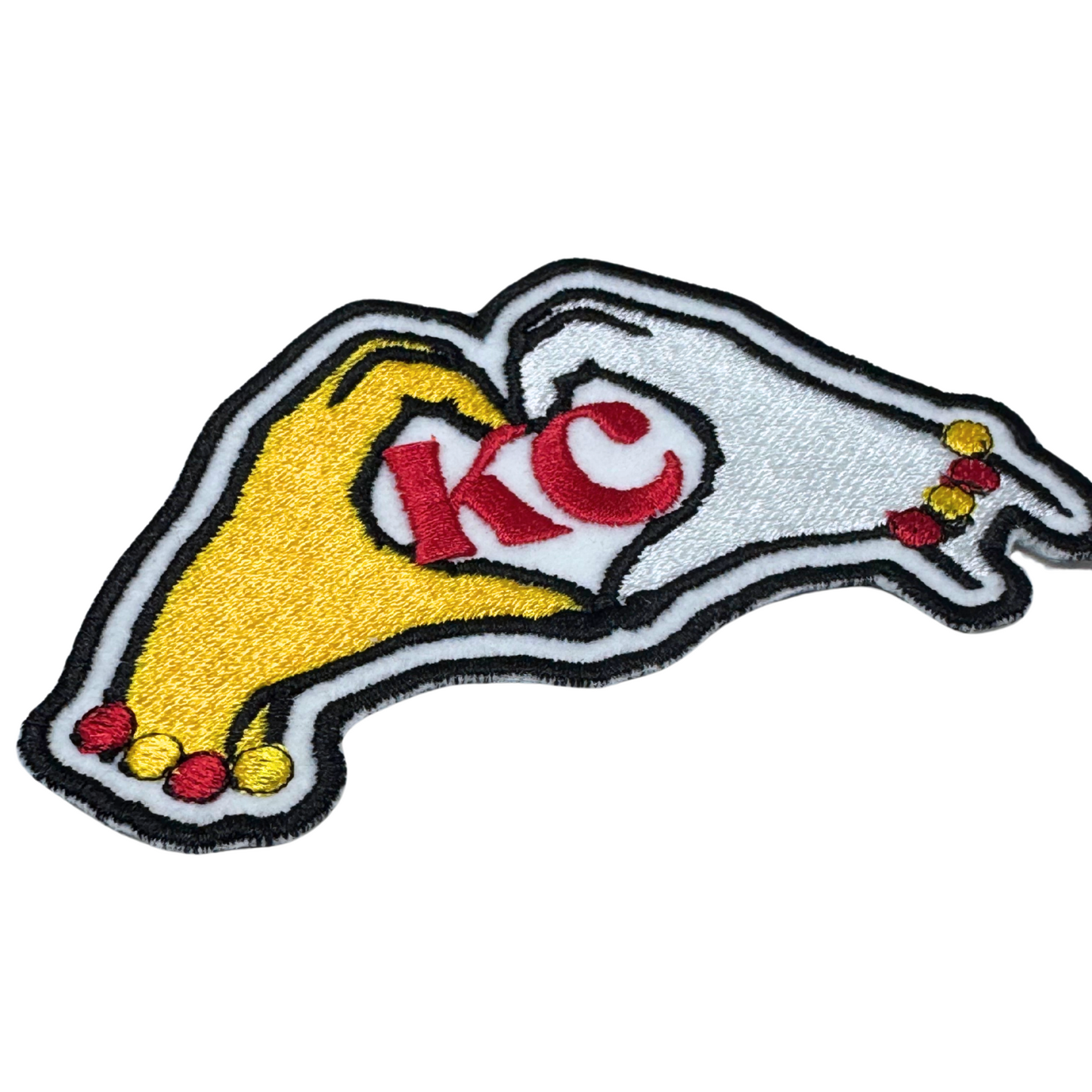angled close-up of Travis and Taylor KC hands patch