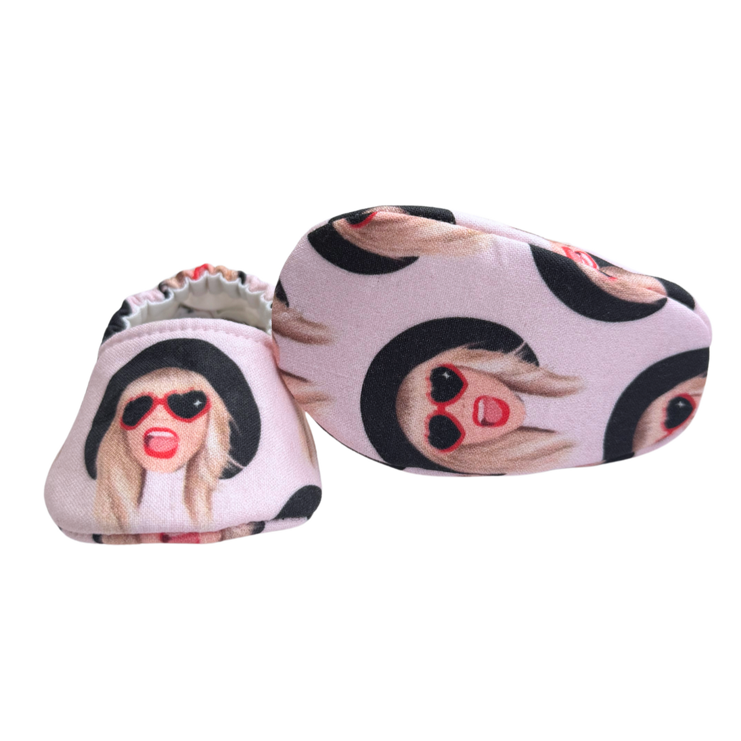 Bottom view of Taylor Swift baby moccasins, featuring a vibrant pink print with a music-inspired theme, perfect for newborns and Swiftie parents.