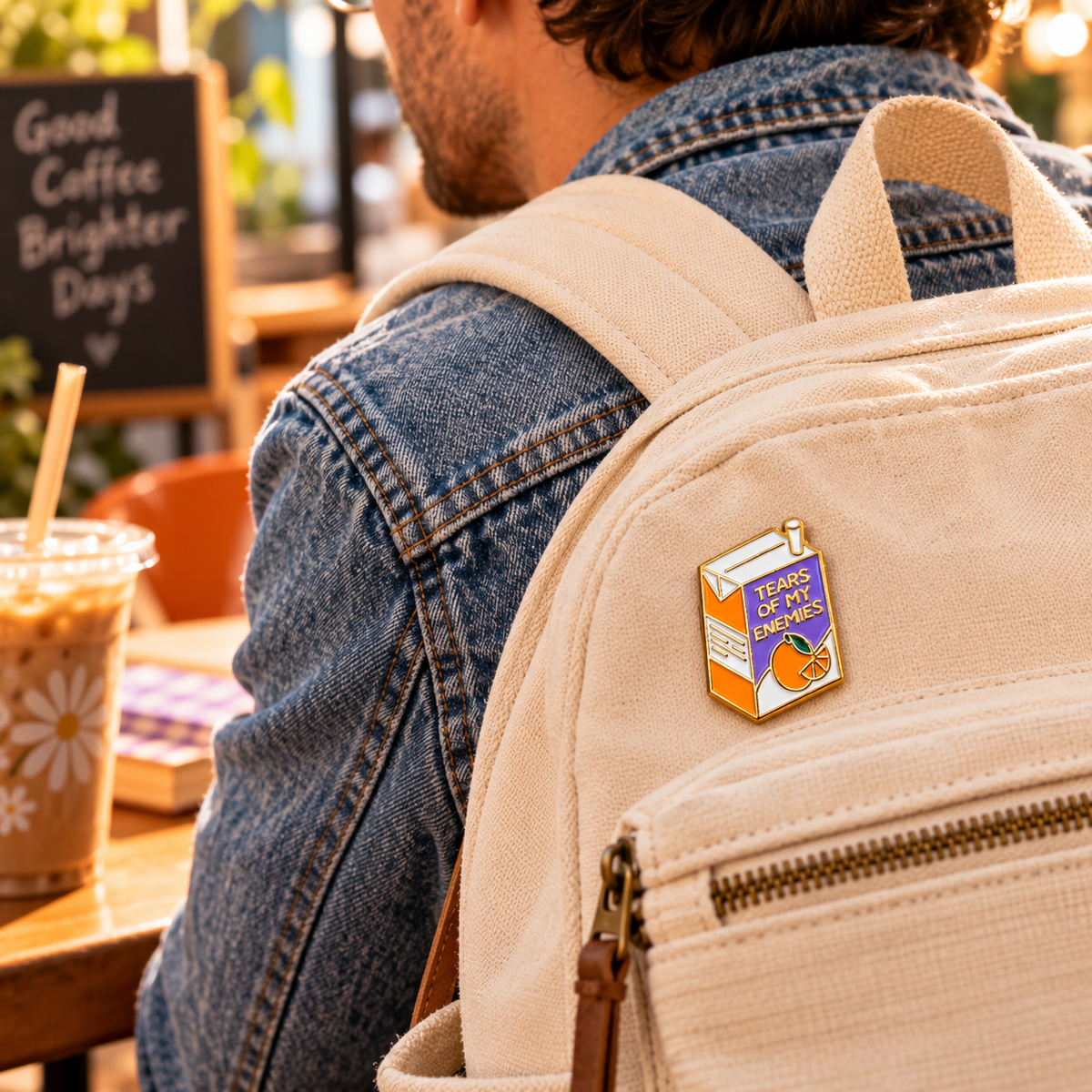 Tears of My Enemies enamel pin on canvas backpack coffee shop lifestyle image