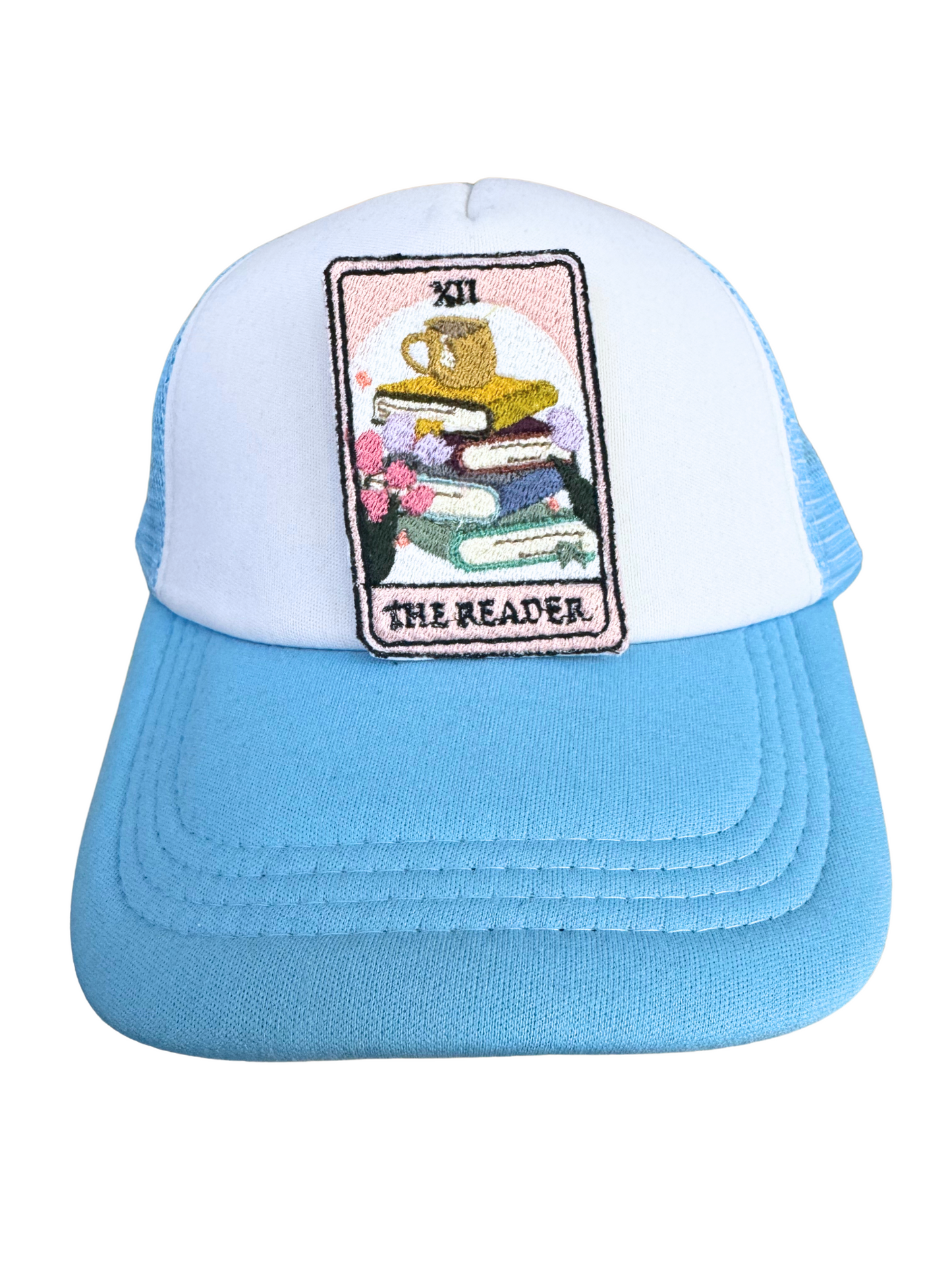 Blue and white trucker hat featuring "The Reader" embroidered patch, perfect for book lovers and tarot enthusiasts.