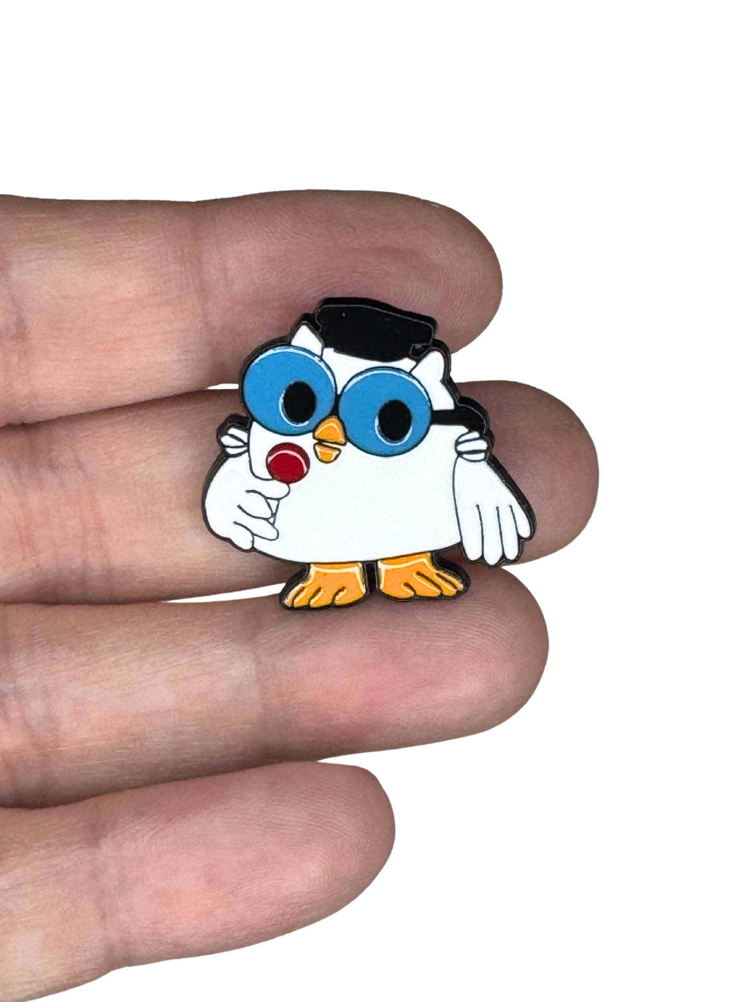 Owl enamel pin held in hand for size reference