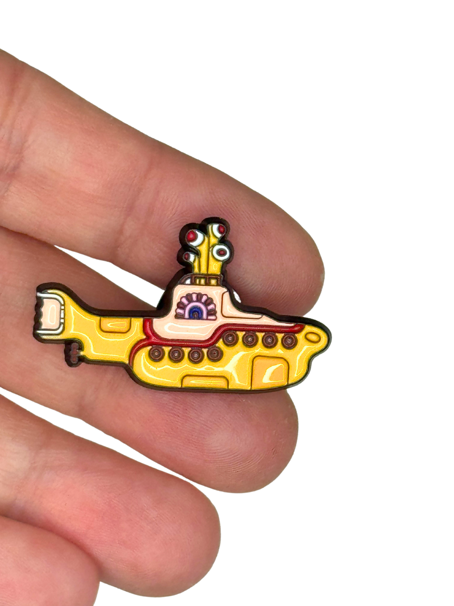“Beatles yellow submarine pin shown on fingers for scale”
