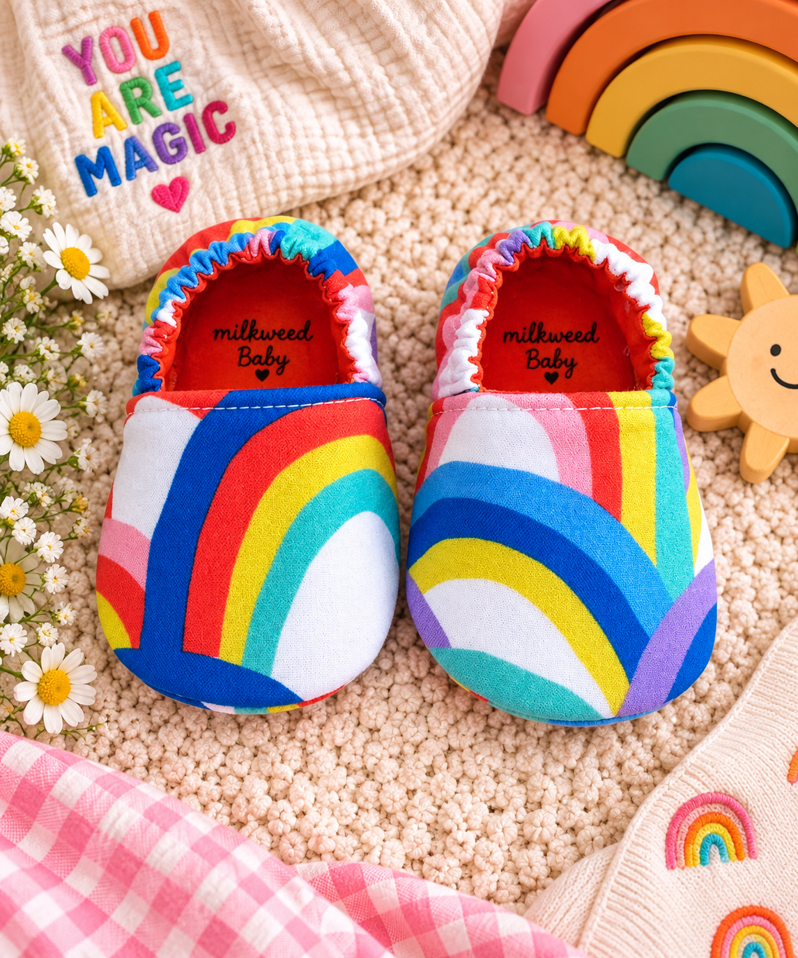 Bright rainbow handmade soft sole baby shoes styled with colorful nursery accessories