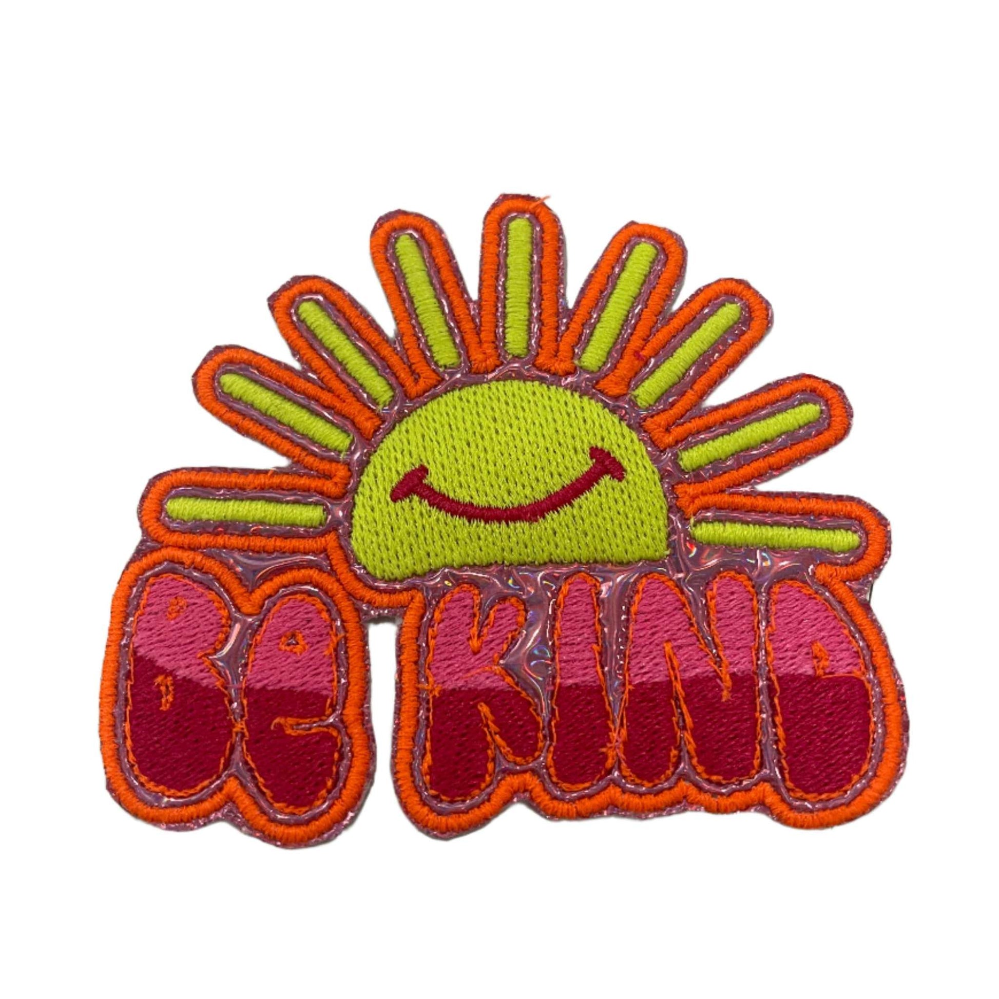 Cheerful sun patch with neon orange outline, two-tone pink "Be Kind" text.