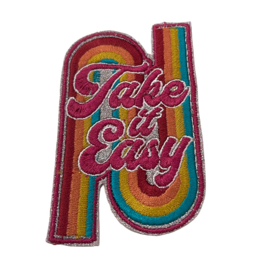 Handmade "Take it Easy" iron-on patch with rainbow glitter and light silver background.