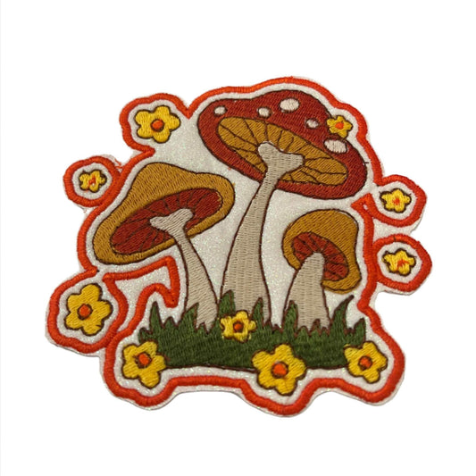 Handmade retro mushrooms and daisies iron-on patch with matte 70s color palette, white glitter background, and orange outline.