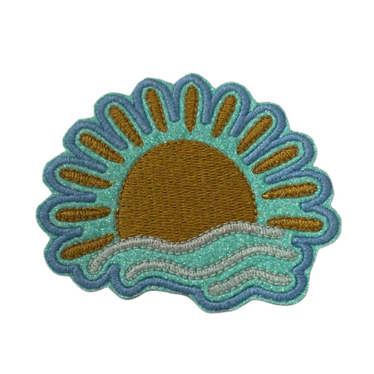 Handmade sunset over ocean patch with copper metallic sun, turquoise waves, and teal border.