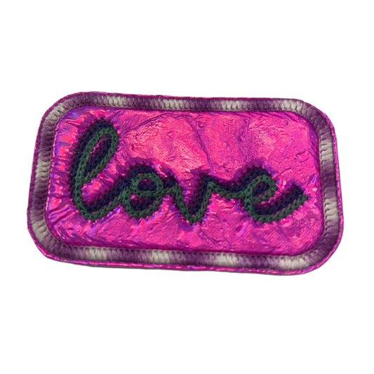 LOVE chain stitch patch in purple, blue, and aqua on bright pink holographic vinyl.
