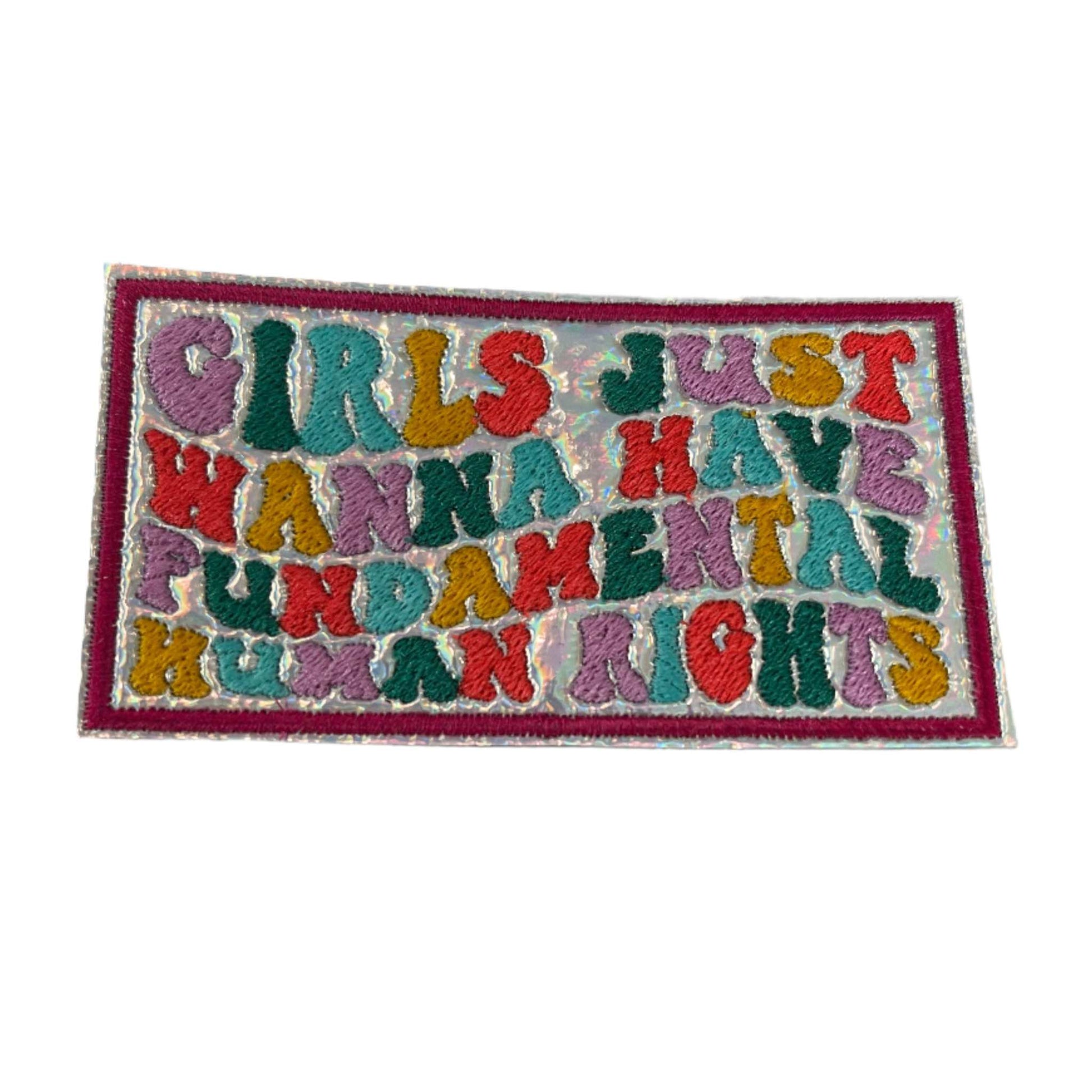 Handmade iron-on patch with multicolor text on a holographic background, message: "Girls Just Wanna Have Fundamental Human Rights".