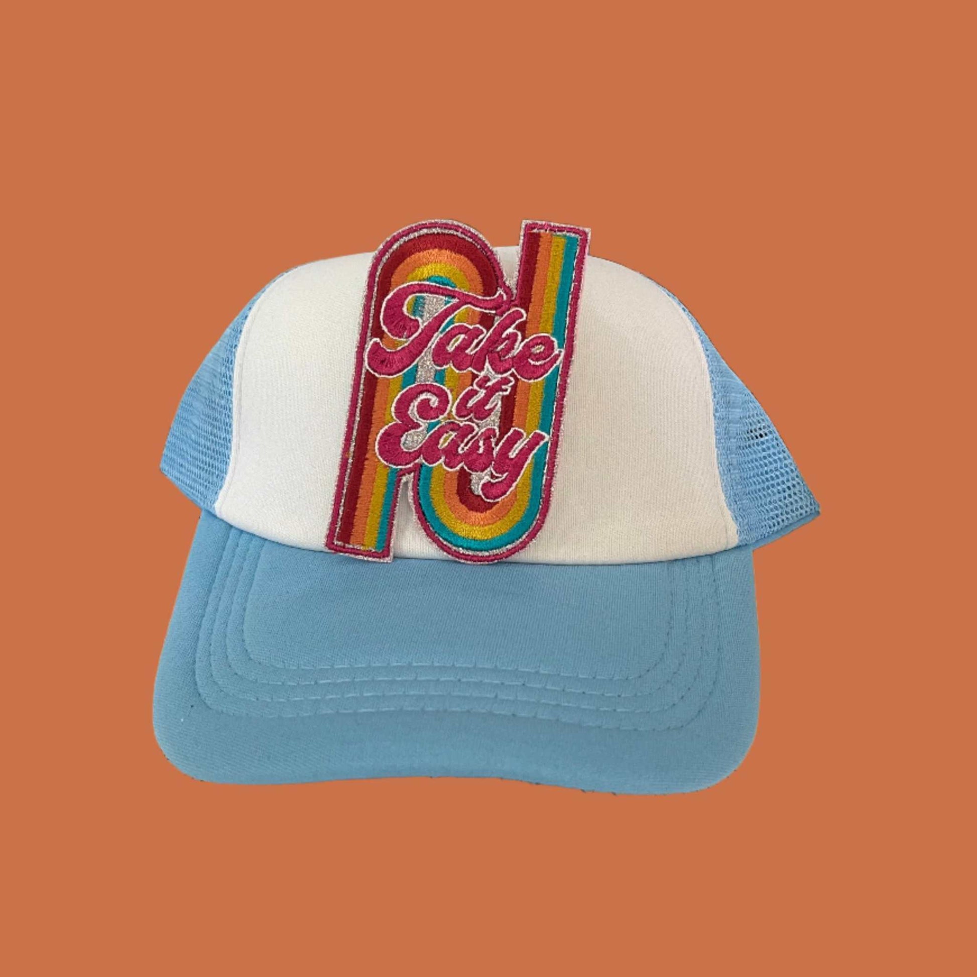 Iron-on patch featuring the words "Take it Easy" in fuchsia with a white outline, set against a rainbow glitter light silver background, with colors including dark pink, orange, greeny yellow, and bright peacock.