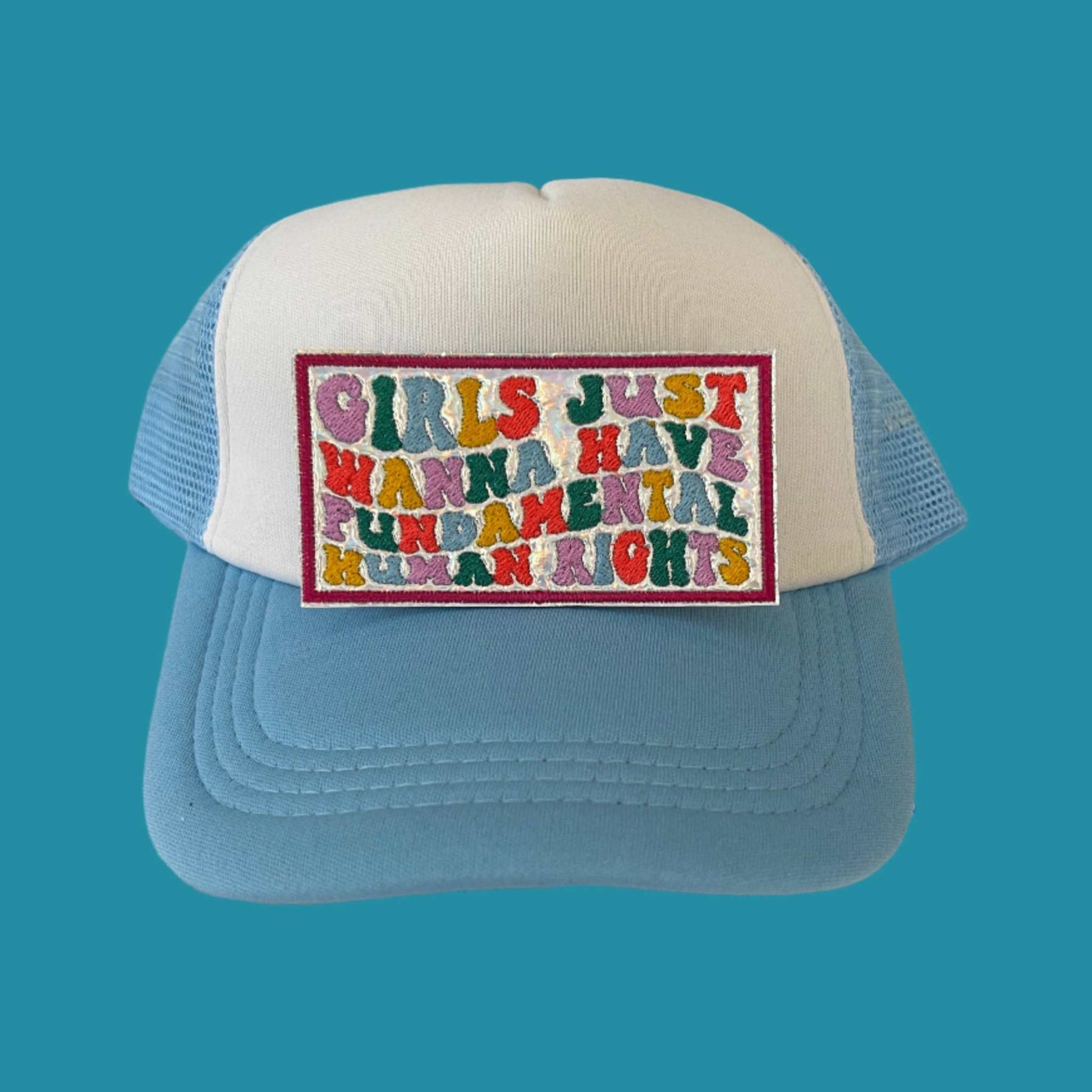Iron-on patch featuring the message "GIRLS JUST WANNA HAVE FUNDAMENTAL HUMAN RIGHTS" in bold, multicolored letters on a holographic background with a red border.