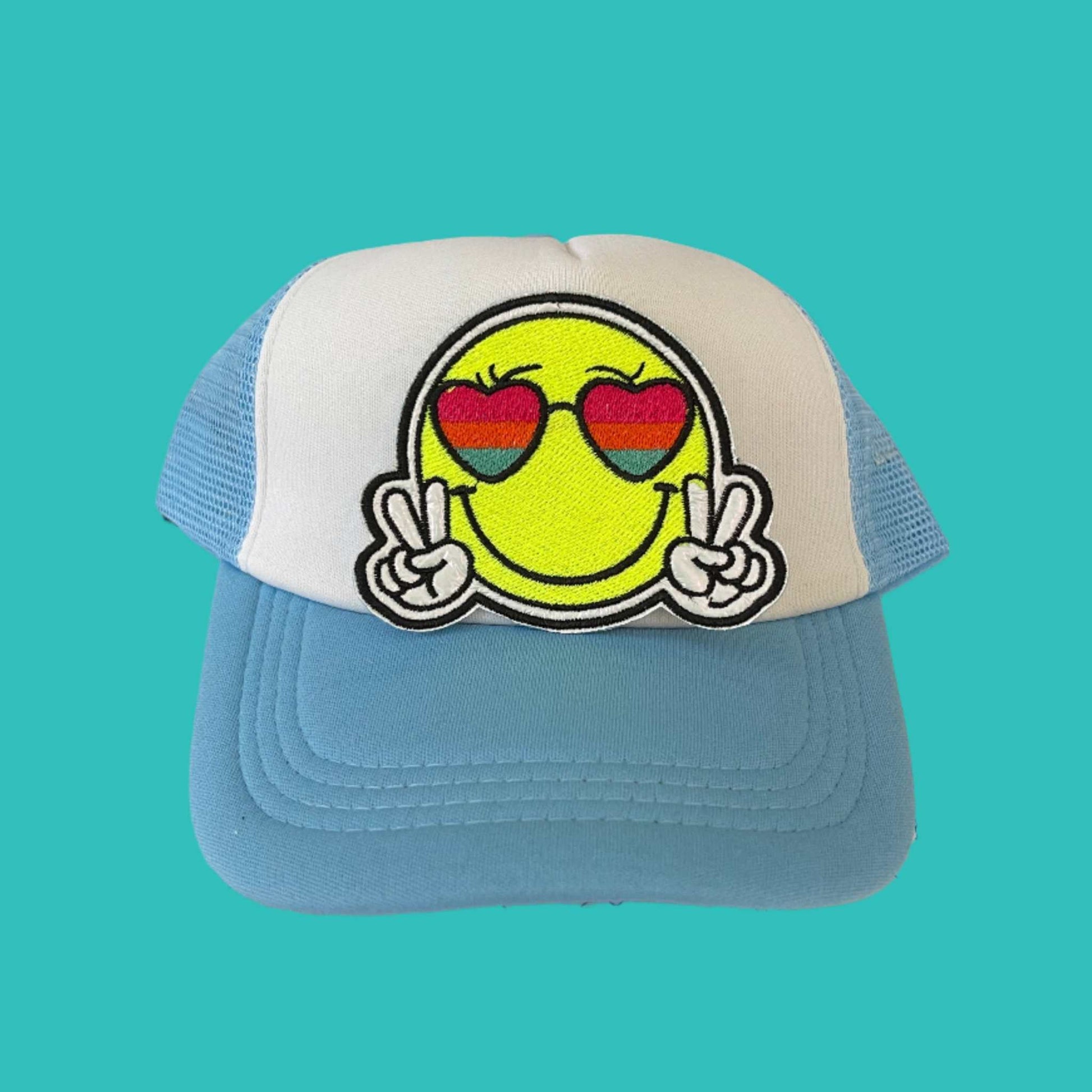 Iron-on patch featuring a yellow smiley face wearing rainbow heart-shaped sunglasses and making a double peace sign, embroidered in vibrant colors and bold black and white threads.