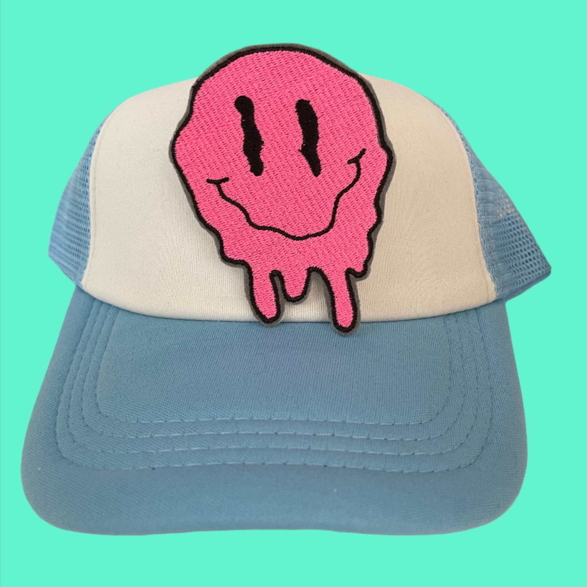 Melting smiley face patch with vibrant pink color and dripping design, perfect for customizing clothing and accessories.