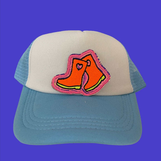 Close-up of a colorful rain boots embroidered patch with pink and orange detailing, perfect for customizing hats and other accessories.