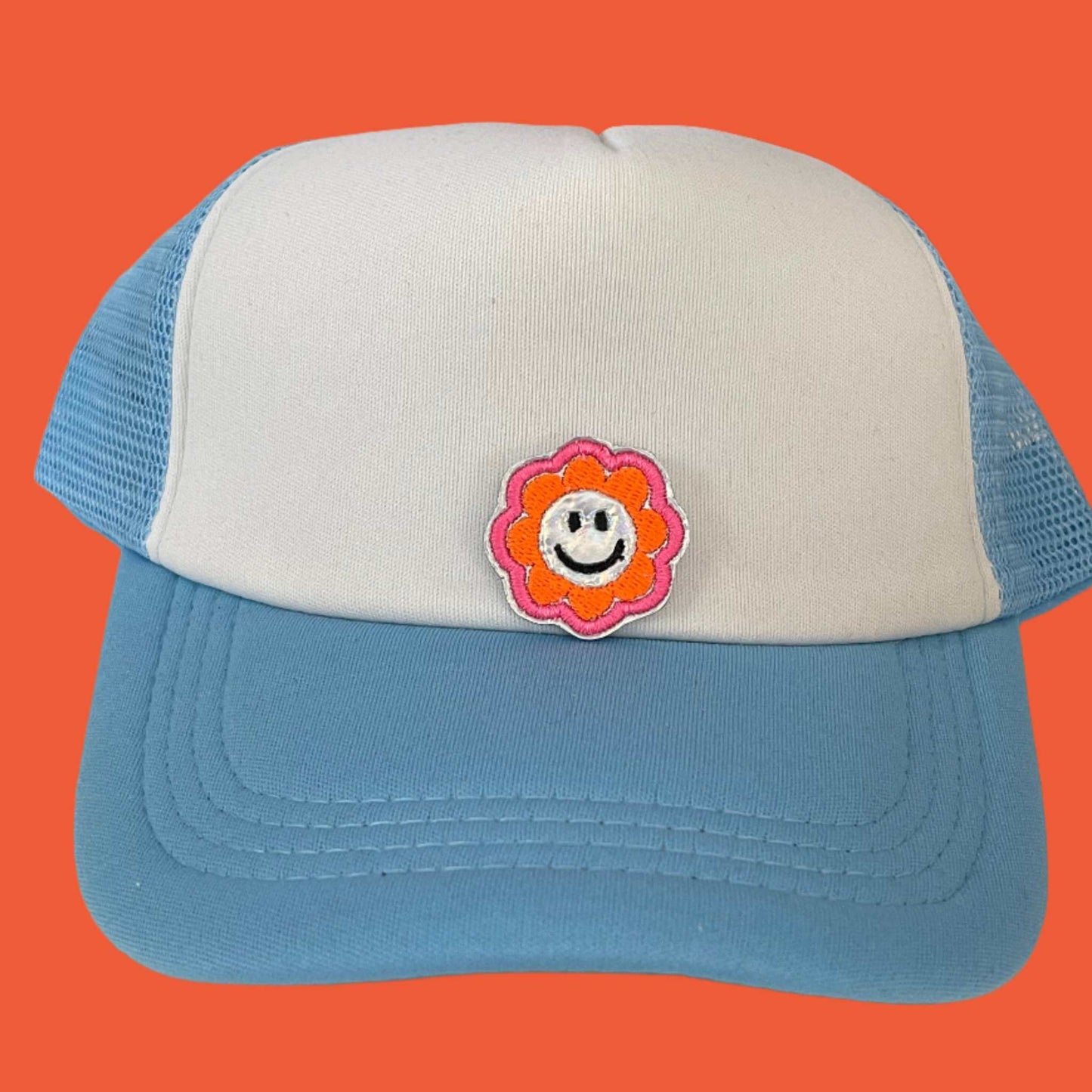 Close-up of a Cheerful Smiley Flower embroidered patch featuring a happy yellow smiley face surrounded by a colorful flower, perfect for customizing hats, apparel, and various accessories.