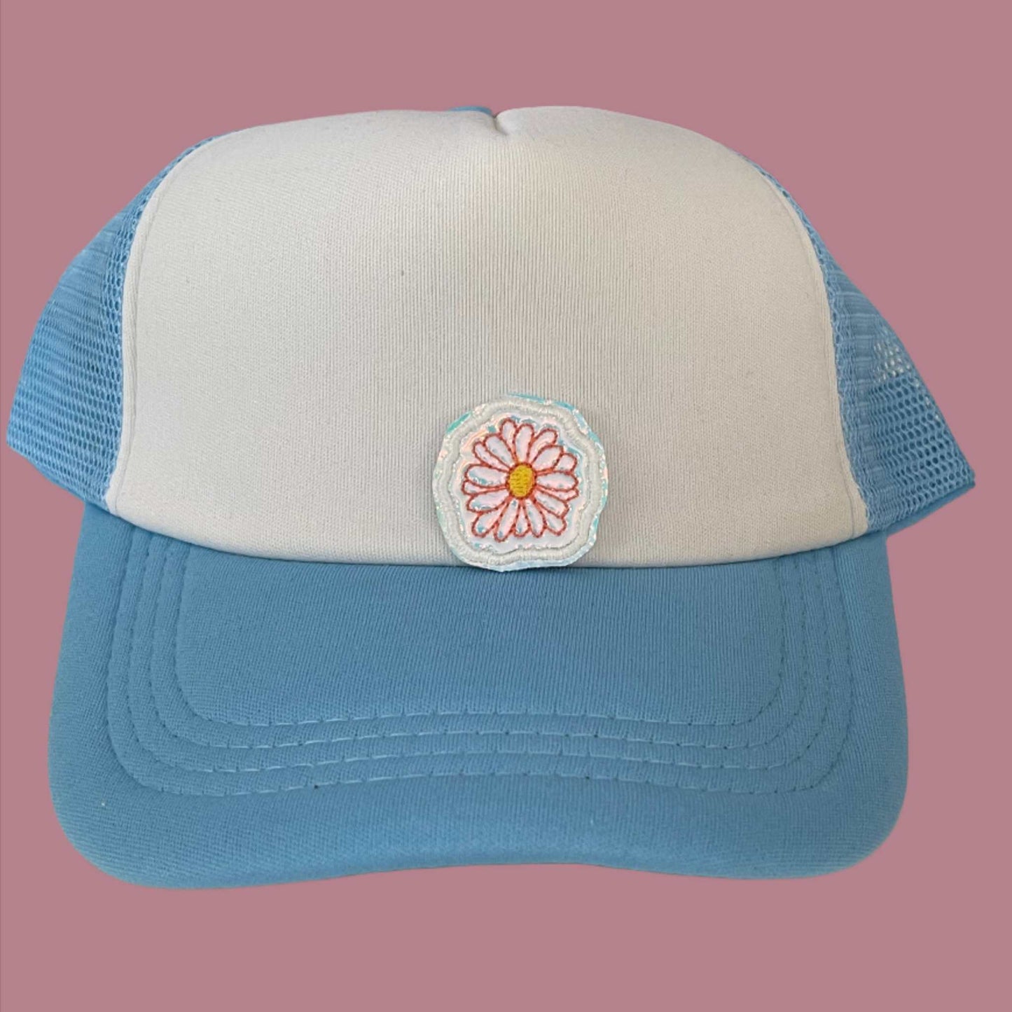 Close-up of a Boho Daisy embroidered patch featuring a delicate pink daisy with a yellow center, perfect for customizing hats, apparel, and various accessories.