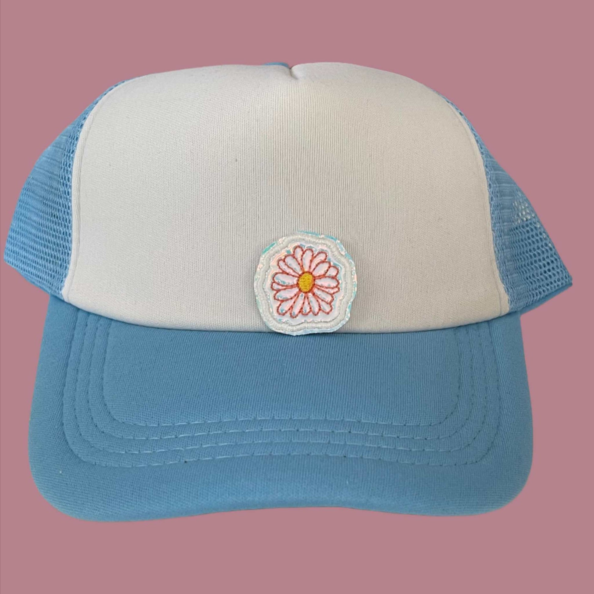 Close-up of a Boho Daisy embroidered patch featuring a delicate pink daisy with a yellow center, perfect for customizing hats, apparel, and various accessories.